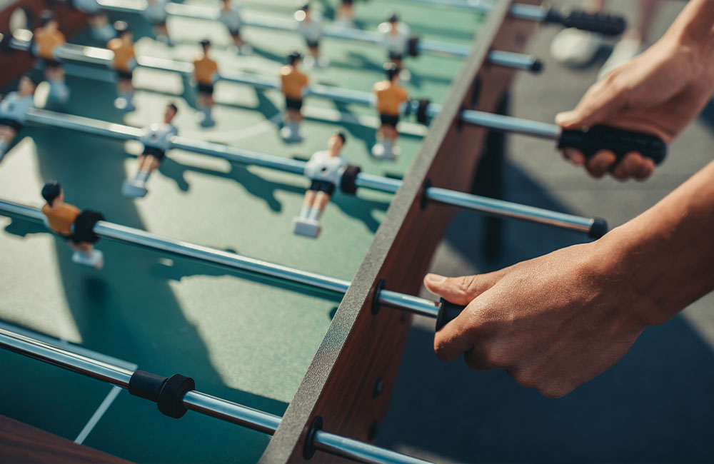 Guy Playing On Foosball Table