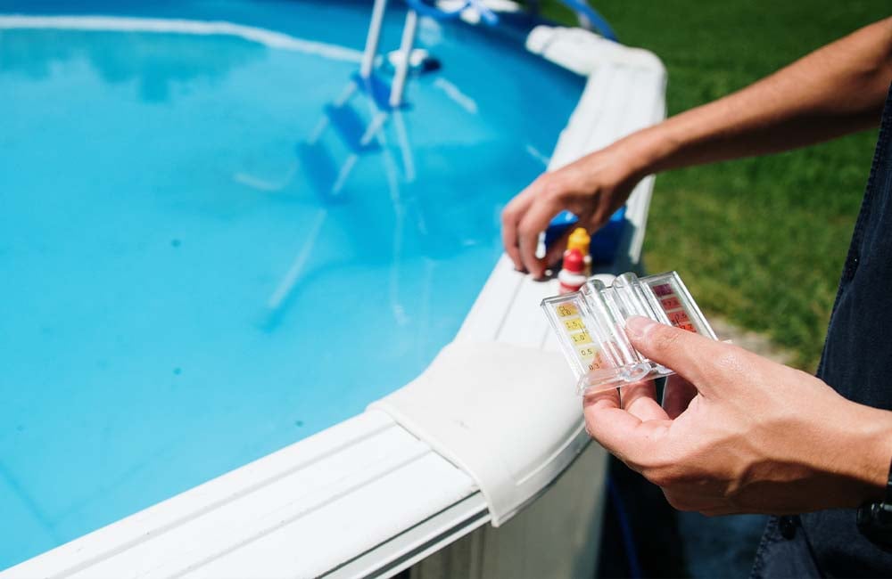 pool water test kit - how often should I test my pool water - young girl underwater in a clean pool