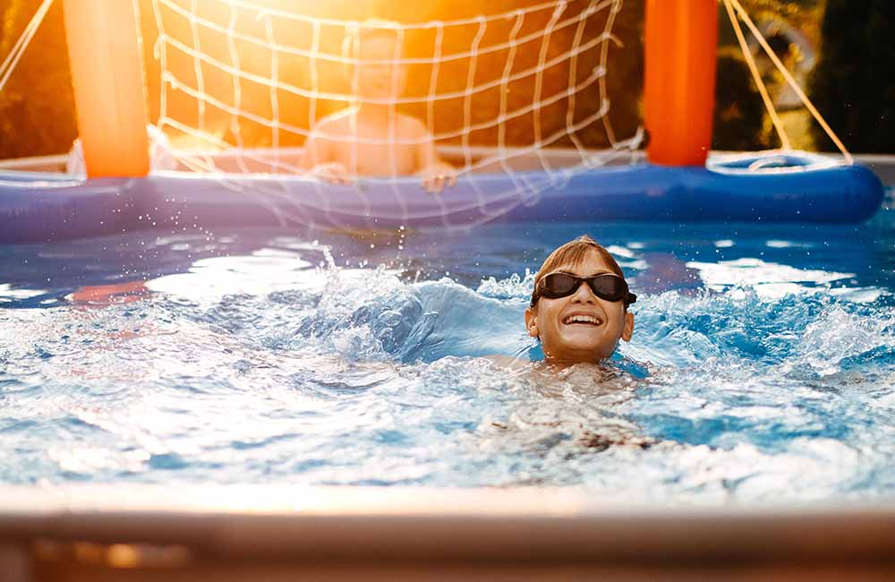 Boy swimming in above ground pool