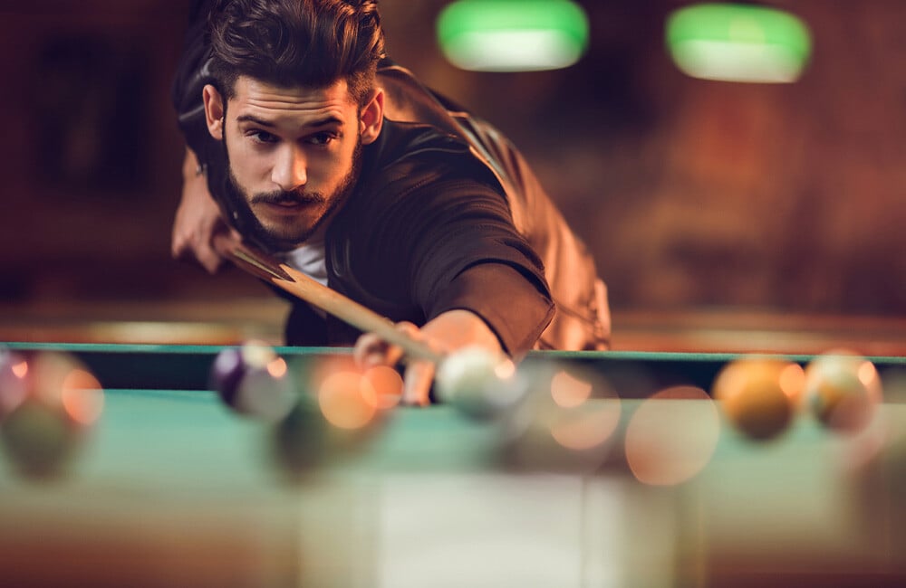 Guy Playing Pool on Billiards Table