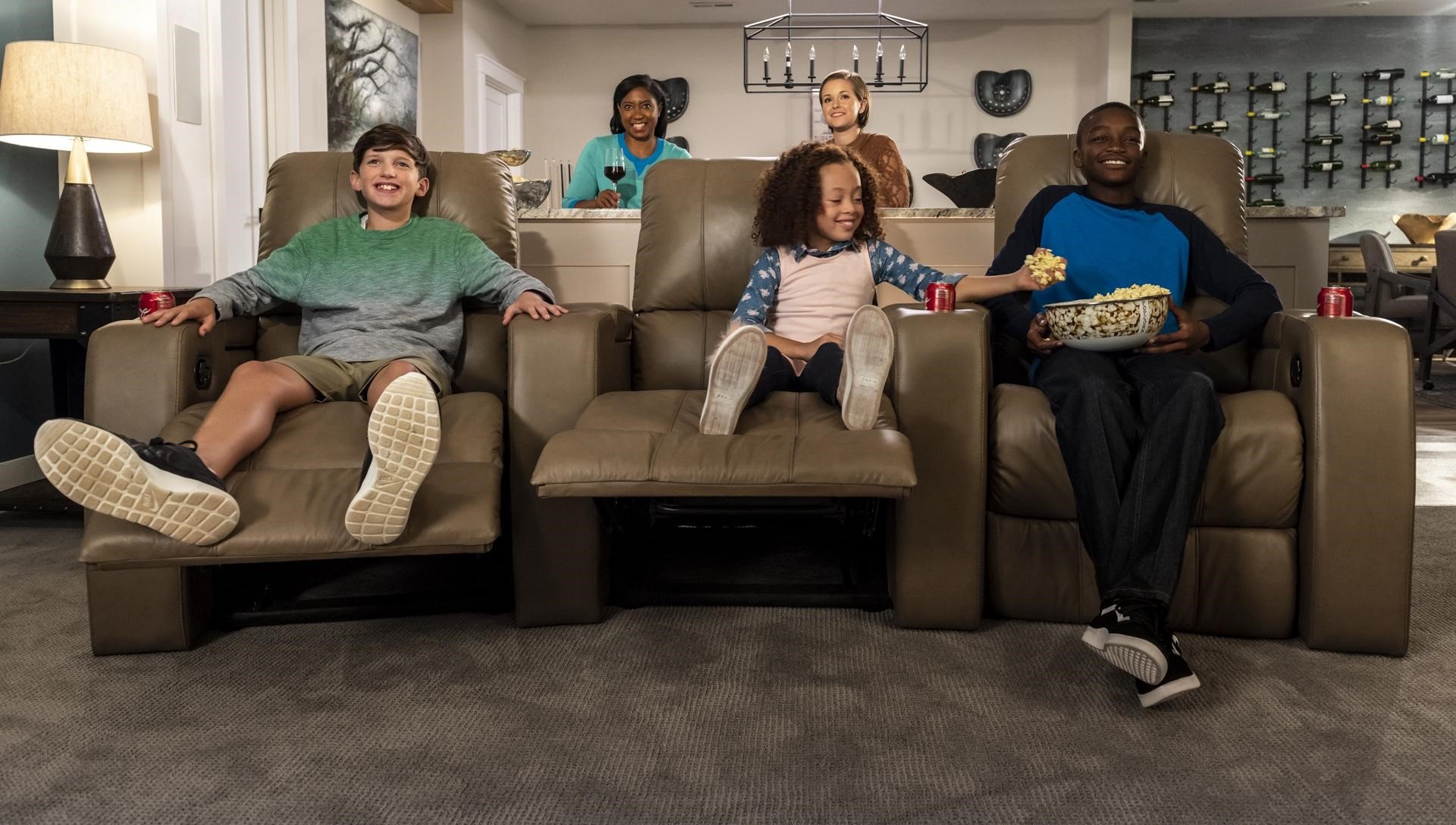 home theater seating - Families and friends enjoying TV on reclining home theater seating.